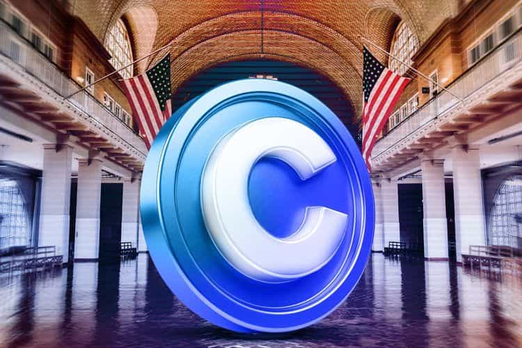 A large Coinbase coin logo in front of an American flag inside a grand architectural space.
